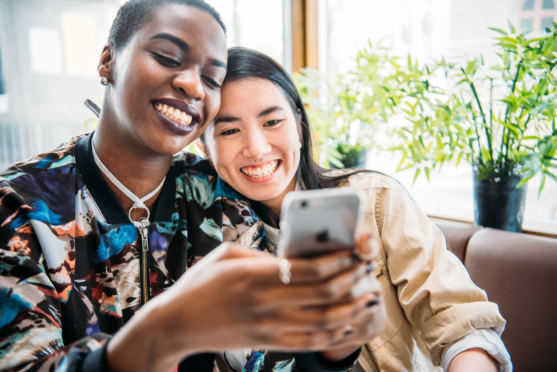 Två personer som håller i en mobiltelefon och ler 
